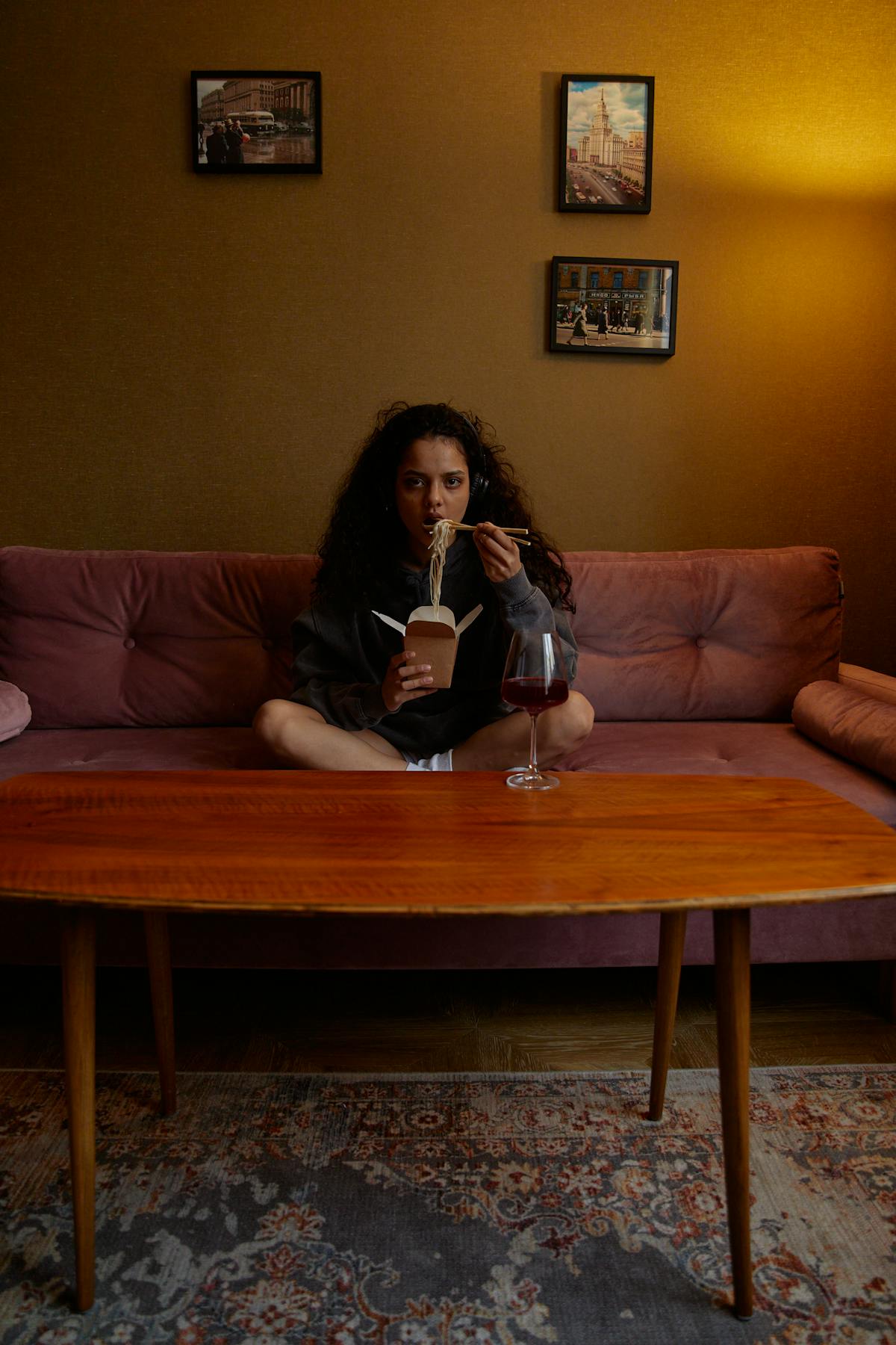 Persoon zit alleen op de bank te eten tijdens een emotioneel moment